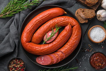 Smoked sausage with sliced on a dark background. Krakow sausage.