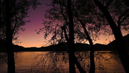 Magnifico tramonto sul lago, con cielo colorato di blu, rosa, giallo e rosso