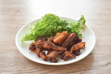 crispy fried pork belly with chili sauce and lettuce on plate