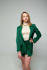 Pretty young female with makeup, wearing in green suit