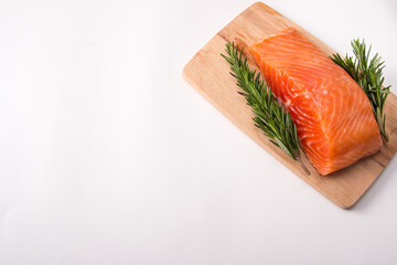 red salted fish on a cutting board with rosemary and lemon