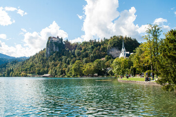 Castle above Lake Bled in Slovenia. A beautiful lake with blue water and above it on a rock stands an old stone castle.