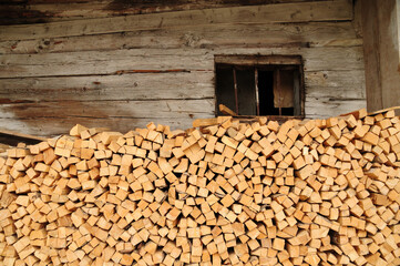 pile of cutted woods accommodated in front of a hut