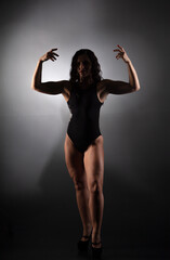 Fototapeta na wymiar Athletic body of young woman over dark background. Fitness concept. 