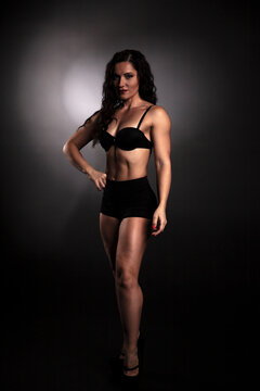 Athletic body of young woman over dark background. Fitness concept. 