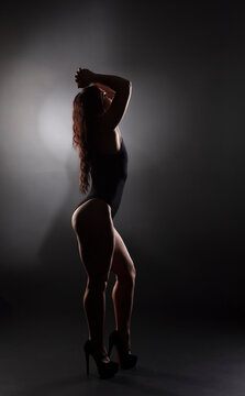 Athletic body of young woman over dark background. Fitness concept. 