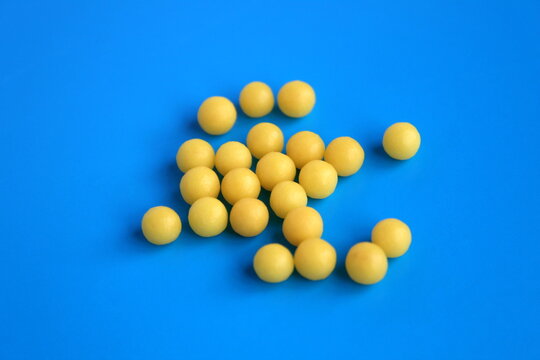Round pills in the form of a ball lie on a blue background.