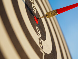 high success concept A red dart arrow aims at the target in the center of the dartboard. Target hit...