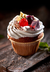 Cupcake decorated with berries on a dark background