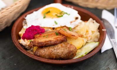 Breakfast of scrambled eggs with fried bacon and potatoes