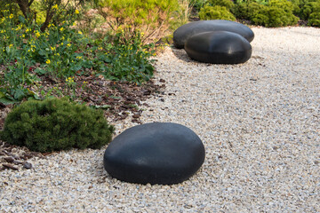 Zen garden dry landscape, or karesansui, japanese rock garden with black stones on white gravel for...