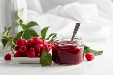 Jar of raspberry jam and fresh berries.