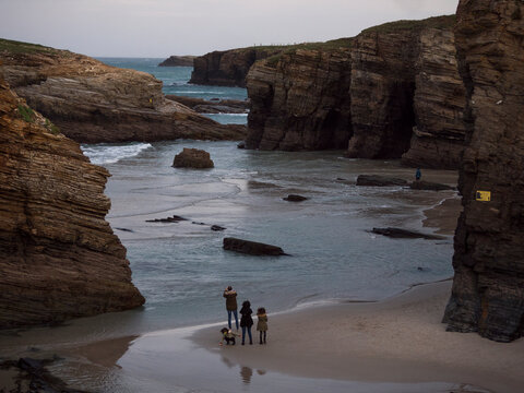 Las Catedrales beach, Ribadeo, Galicia, Spain. Family making photos of the landscape on a winter day.