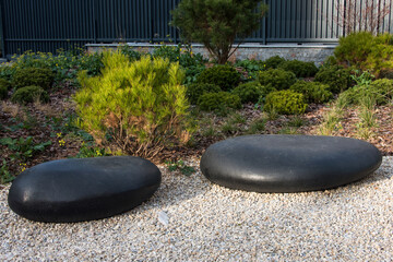 Zen garden dry landscape, or karesansui, japanese rock garden with black stones on white gravel for...