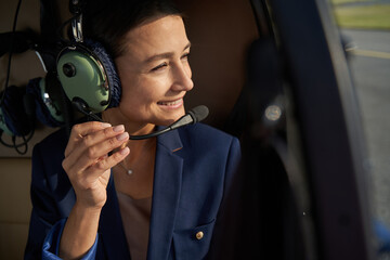 Pleased woman in noise-canceling headphones sitting in chopper © Viacheslav Yakobchuk