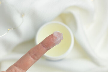 Closeup of a person applying petroleum jelly to their hand.
