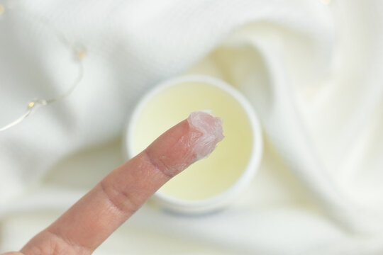 Closeup of a person applying petroleum jelly to their hand.