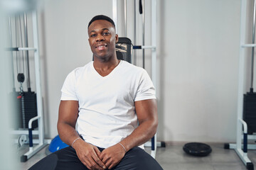 Sporty man seated at gym looking ahead
