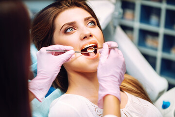 Young woman  at the dentist's chair during a dental procedure. Overview of dental caries prevention. Healthy teeth and medicine concept.