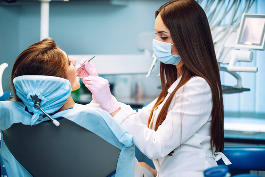 Young woman  at the dentist's chair during a dental procedure. Overview of dental caries prevention. Healthy teeth and medicine concept.