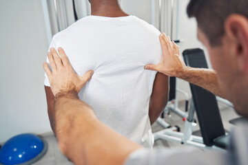 Professional physical therapist palpating patient paraspinal muscles - obrazy, fototapety, plakaty