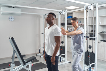 Qualified physiatrist examining spine of young man