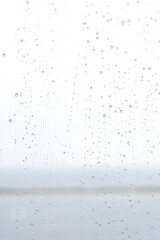 Sky background with water drops on a glass window