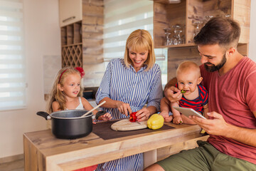 Parents and children cooking dinner together