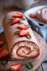 Delicious strawberry roll cake with white cream, homemade baked dessert