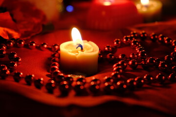 
Fortune-telling on fire and a ring, Russian divination for love at Christmas. Burning red candles, heart shaped candles, ruby ​​beads on the table. Occult concept. February 14 decoration.