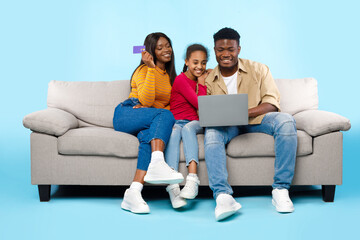 Fototapeta na wymiar Black family using laptop computer and credit card