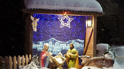 Nativity scene with wood figurines of Jesus, Mary, Joseph, sheep and magi, an angel. Christmas installation with figurines of biblical characters