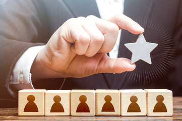 A businessman is holding a star over the team. Awarding. High appreciation and reward for work. Optimal team size, efficiency and productivity. Recruiting the best job applicants.