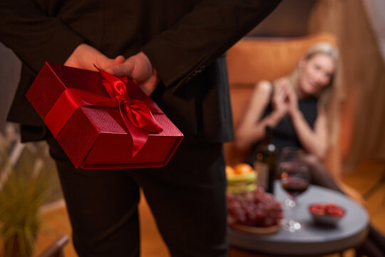 Gift, held by man behind his back in restaurant