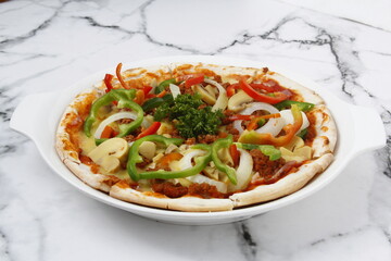 Freshly made pizza with meat and vegetable toppings