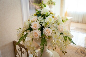 Bouquet of roses stands in vase on table