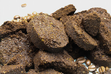 Closeup of isolated pile pressed coffee grounds tabs from automatic machine, white background