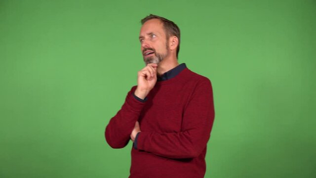 A middle-aged handsome Caucasian man thinks about something and walks back and forth - green screen background