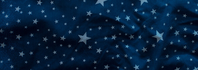 Dark blue textile background with white stars. Banner.