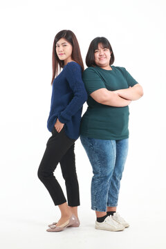 Portrait. Two fat and skinny Asian women. standing on a white background Happy smile. The concept of health care to lose weight.