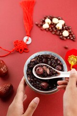Making Laba Porridge, Chinese Traditional Congee Served at Laba Festival. Top View on Red Theme