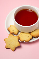 Homemade shortbread cookies on a pink background. Delicious and light dessert. Cup of tea with cookies