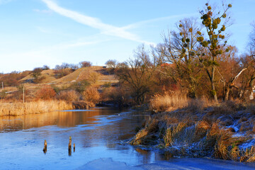 First frosts. The river starts to ice. Winter river. Rural landscape. Cold mountain river.