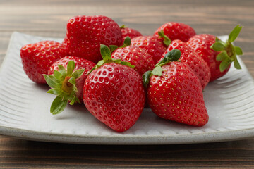 平たい皿に盛り付けられた旬の甘いイチゴ