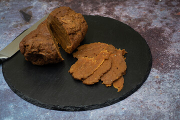 Home made seitan ham and thin  seitan slices on slate board