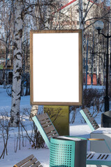 Billboard on the street in the city with an empty white space for text on a background of trees in frost, snow, blue sky, beautiful winter background, mockup