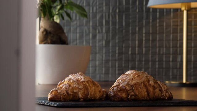 Two fresh delicious croissants on a tray on the table