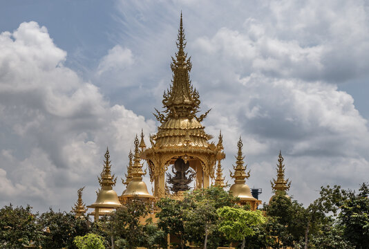 Chiang Rai, Thailand - Sep 05, 2020 : Elaborate sculptures of golden pagoda at the famous Wat Rong Khun (White Temple) in Chiang Rai, Thailand. Selective Focus.