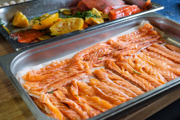 Salted and sliced pink fresh salmon, laid out on a baking sheet.