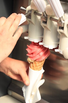 Hand holding waffle cone with twisted ice cream